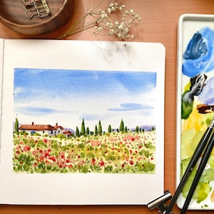 Puede incluir: Pintura acuarela de un paisaje campestre con una pequeña casa, árboles y un campo de flores rojas. La pintura está en una hoja de papel blanco y está rodeada de un marco blanco.