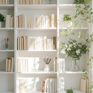 May include: A white bookcase filled with books, plants, and decorative items. The books have beige covers, and small potted plants are placed on the shelves. Trailing green vines and flowers add a natural touch to the display.