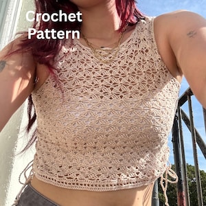 May include: A beige sleeveless crochet top featuring a repeating floral-inspired openwork pattern, a round neckline, and adjustable side drawstrings with hanging ties. The text "Crochet Pattern" is visible in the upper left corner of the image.