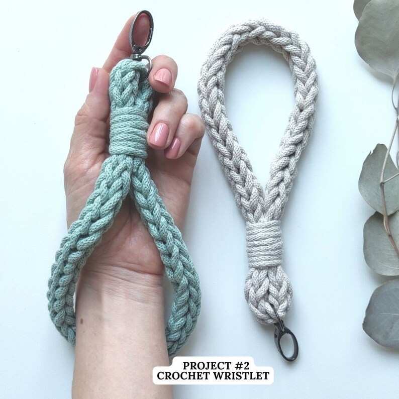 Peut inclure: Deux bracelets en crochet, l'un de couleur vert clair et l'autre de couleur beige. Les deux bracelets sont munis d'un fermoir m&eacute;tallique &agrave; l'extr&eacute;mit&eacute;. Le texte "PROJECT #2 CROCHET WRISTLET" est en bas de l'image.