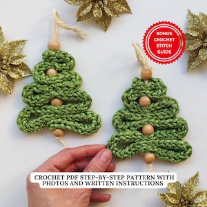 Peut inclure: Deux décorations de Noël en forme de sapin de Noël crochetées en vert avec des perles en bois. Les décorations sont suspendues à une ficelle blanche. L'image comprend le texte "BONUS CROCHET STITCH GUIDE" et "CROCHET PDF STEP-BY-STEP PATTERN WITH PHOTOS AND WRITTEN INSTRUCTIONS".