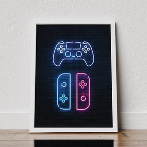May include: A framed print with a neon blue and pink design of a video game controller and a video game console on a black brick wall background.