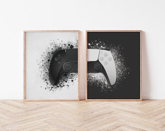 May include: Two framed prints of video game controllers, one black and one white, with a splatter effect background.