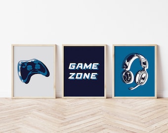 Könnte beinhalten: Drei gerahmte Drucke mit einem Gaming-Thema. Der linke Druck zeigt einen blauen Videospiel-Controller. Der mittlere Druck zeigt den Text "GAME ZONE" in Blau und Weiß. Der rechte Druck zeigt ein blaues und weißes Gaming-Headset.