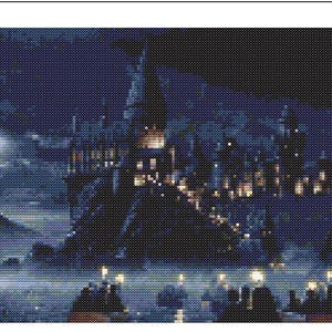 May include: A cross-stitch pattern depicting a large castle perched on a rocky cliff at night. The scene features a bright moon, dark blue sky, and glowing yellow windows throughout the structure, with small lights reflecting on the water below.