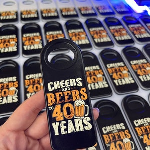 May include: Black bottle opener with a white and orange design that says "Cheers and Beers to 40 Years".