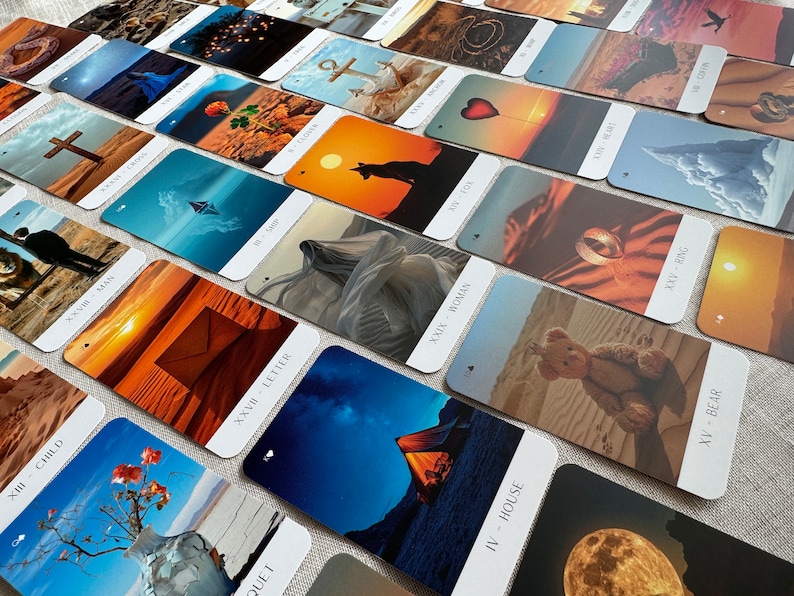 May include: A set of tarot cards with colorful images and text on each card. The cards are laid out in a fan shape on a light brown surface. The text on the cards includes the names of the cards, such as "Child", "Letter", "House", "Woman", "Bear", and "Ring".