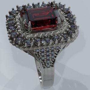 May include: A silver ring with a large red gemstone surrounded by smaller clear gemstones.