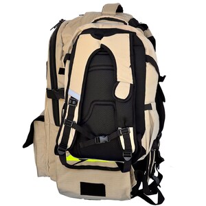 K&ouml;nnte beinhalten: Ein beigefarbener und schwarzer Rucksack mit mehreren F&auml;chern und verstellbaren Riemen. Der Rucksack verf&uuml;gt &uuml;ber ein gepolstertes R&uuml;ckenteil und Schultergurte f&uuml;r Komfort. Er hat eine kleinere, abnehmbare Tasche vorne. Das Design umfasst reflektierende Elemente.