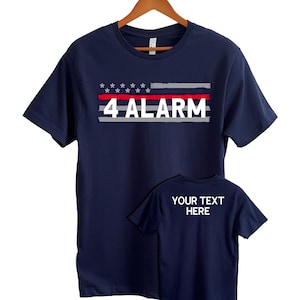 May include: Navy blue t-shirt with a red, white, and blue American flag design and the text "4 ALARM". The shirt also has a blank space for text on the bottom.