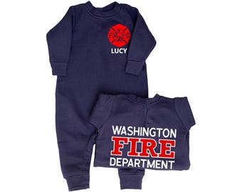 Könnte beinhalten: Zwei marineblaue Baby-Strampler. Einer hat ein rotes Feuerwehr-Emblem mit dem weißen Namen "LUCY". Der andere hat die Worte "WASHINGTON FIRE DEPARTMENT" in Weiß und Rot.
