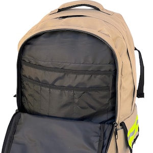 K&ouml;nnte beinhalten: Beigefarbener Rucksack mit mehreren Innentaschen und einem gro&szlig;en Hauptfach. Der Rucksack hat einen schwarzen Rei&szlig;verschluss und einen schwarzen Griff oben. Der Innenraum ist schwarz. An der Seite befinden sich reflektierende gelbe Streifen.
