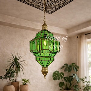May include: A green glass pendant lamp with a geometric design, hanging from a chain. The lamp has brass accents and the text "World of Lamp". The ceiling features a decorative geometric pattern.