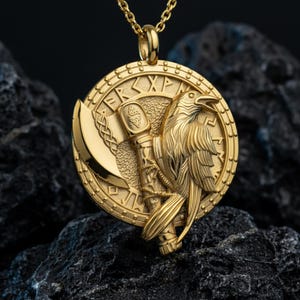 May include: Gold-colored pendant necklace featuring a detailed raven, axe, and runes. The round pendant has a textured border and is suspended from a delicate chain. The raven is perched beside an axe, with intricate detailing.