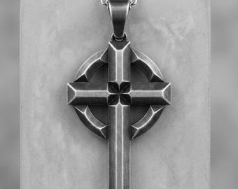 Op de afbeelding: Een Keltische kruishanger van zilverkleurig metaal met een geborstelde afwerking en een centraal ringontwerp. Het kruis hangt aan een bijpassende zilverkleurige metalen ketting en heeft scherpe, hoekige randen en een verweerde uitstraling.