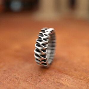 Sterling silver modern ring showing continuous wave motif with dimensional details