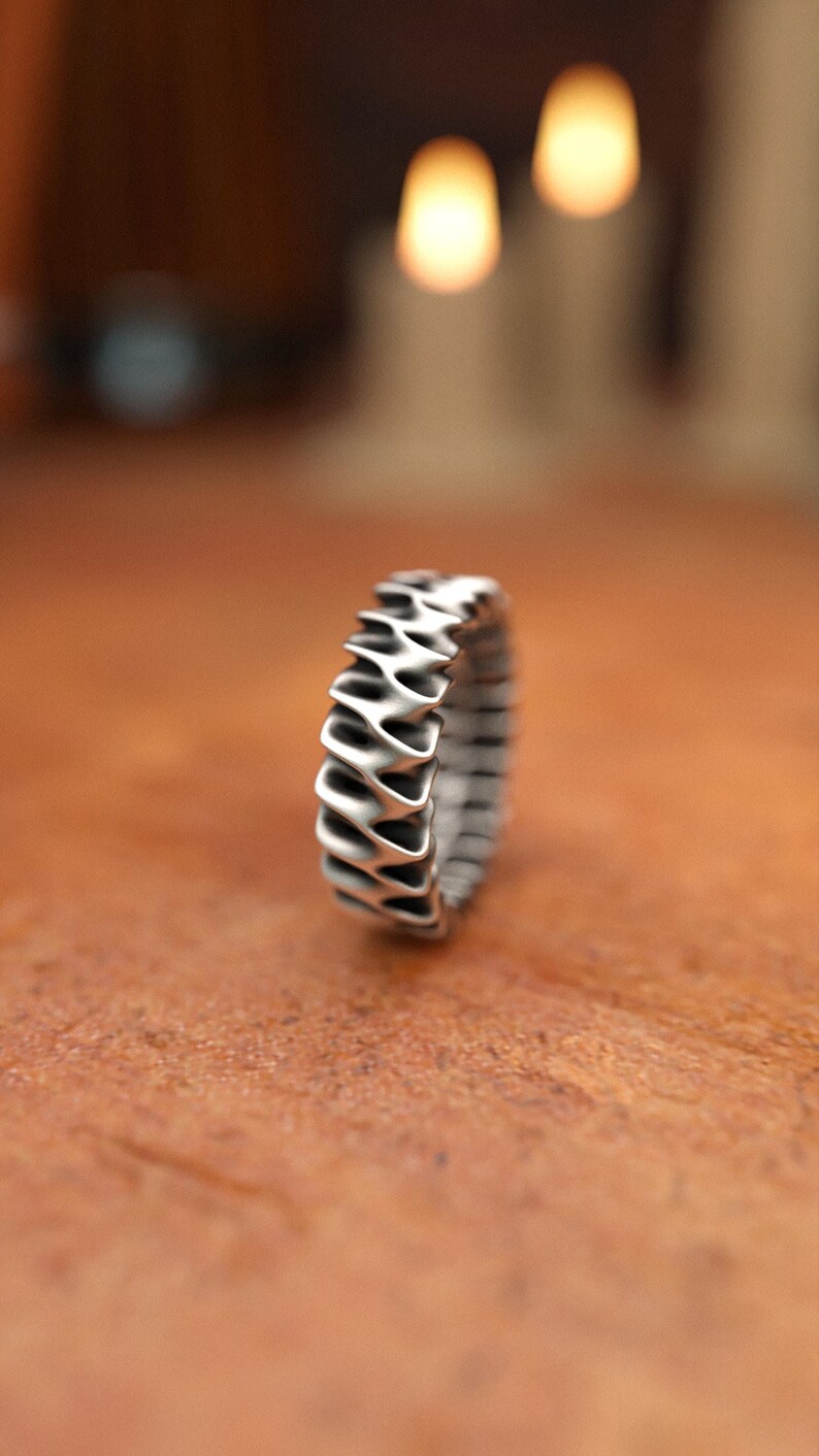 Sterling silver modern ring showing continuous wave motif with dimensional details