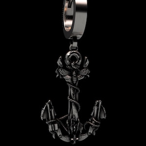 Könnte beinhalten: Silberfarbener Ankeranhänger mit detailliertem Design, einschließlich einer Motte und Seilakzenten. Der Anhänger ist an einem Scharnierring befestigt. Schwarzer Hintergrund.