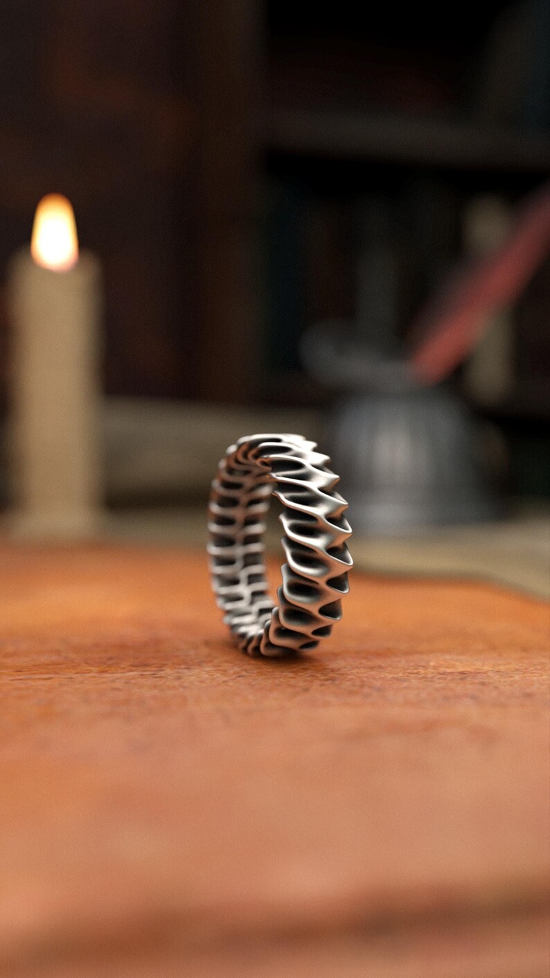 Contemporary style ripple ring in matte sterling silver with architectural wave pattern