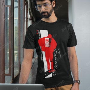 May include: Black t-shirt with a red and white graphic design. The design includes a stylized figure, the words "Famous Style", and the text "Brooklyn-London-Paris-Dubai". The shirt is worn by a person.