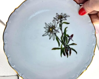 Plato de postre o ensalada Schumann Arzberg, alemán, con flores de edelweiss. Borde festoneado y ondulado con ribete de oro de 24 quilates.