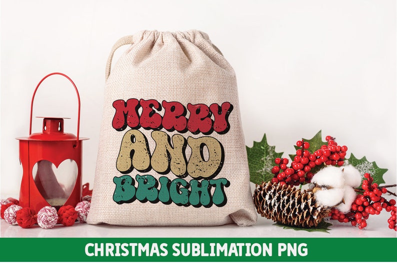 May include: A white canvas bag with a red, yellow, and green "Merry and Bright" design. The bag is sitting on a white surface with a red lantern, pine cones, and red berries.