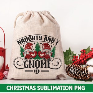 May include: A white burlap bag with a red and green gnome design. The bag has the text "Naughty and I Gnome It" printed on it. The bag is sitting on a white surface with a red lantern and a sprig of holly.