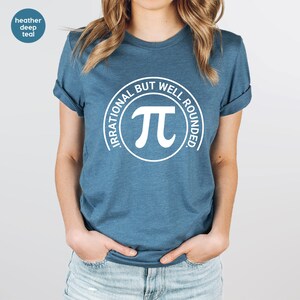 May include: A heather deep teal t-shirt with a white circle graphic that says "Irrational But Well Rounded" with a white pi symbol inside the circle.