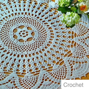 Op de afbeelding: Wit gehaakt tafellaken met een delicaat bloemenpatroon. Het tafellaken is rond en heeft een centraal ontwerp met een stervorm. De tekst Crochet Pattern is zichtbaar onderaan de afbeelding.