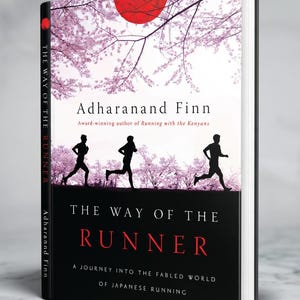May include: A book titled "The Way of the Runner" by Adharanand Finn. The cover shows a red sun, cherry blossoms, and running silhouettes. The spine displays the author's name and the book's title.