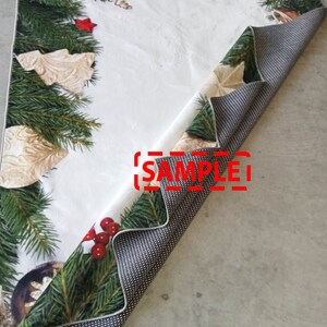 May include: A Christmas-themed table runner with a white background and festive green fir branches, red berries, and gold ornaments. The reverse side features a black and white dotted pattern. The word "SAMPLE" is visible.