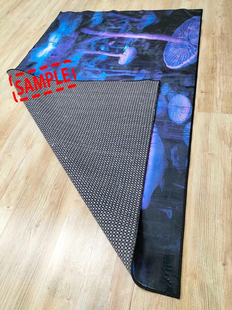 Puede incluir: Una alfombra azul y negra con un dise&ntilde;o de setas psicod&eacute;licas. La alfombra tiene un respaldo antideslizante.