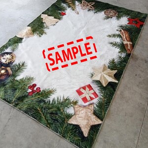 May include: Rectangular Christmas-themed rug with a white center and a border of green pine branches, gold ornaments, and red berries. The rug features gold stars, a red gift box, and the word "SAMPLE" in red.