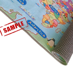 May include: A rolled-up, light blue children's rug featuring a colorful world map design. The rug has a penguin illustration and the word "Antarctica" in blue. The word "SAMPLE" is stamped in red across the corner.