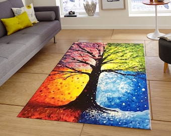 May include: A colorful rug featuring a stylized tree with four seasons depicted in each quadrant. The tree is black with a brown trunk and branches. The seasons are represented by red, orange, yellow, green, blue, and white colors.