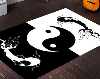 May include: Black and white rug featuring a yin yang symbol in the centre and two stylised fish on either side. The fish are facing opposite directions.