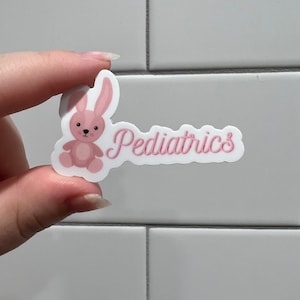 May include: A pink bunny sticker with the word "Pediatrics" in pink cursive lettering.