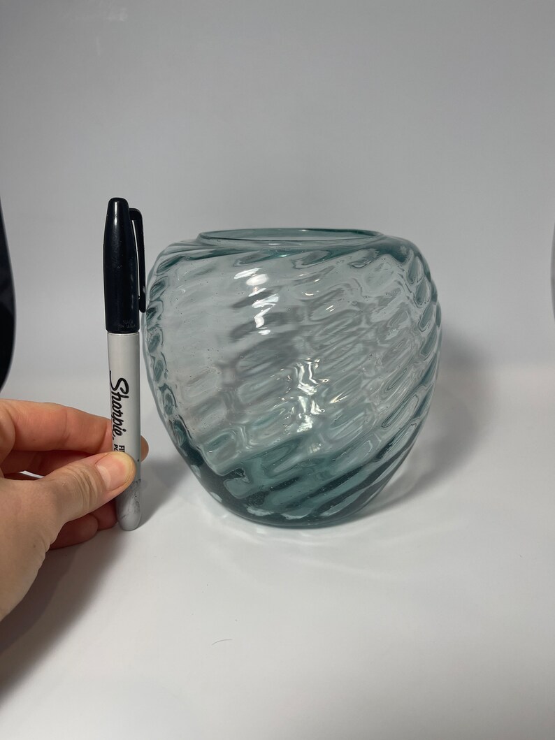 May include: A clear glass vase with a textured, wavy design. The vase is approximately 5 inches tall.