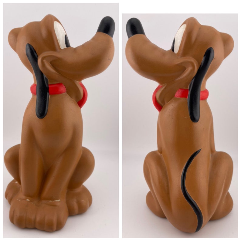 Puede incluir: Una figurita de cer&aacute;mica marr&oacute;n de Pluto, el perro de Disney. Pluto est&aacute; sentado con la cola enroscada detr&aacute;s de &eacute;l y lleva un collar rojo.