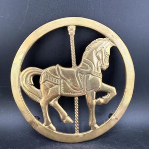 Könnte beinhalten: Eine weiße Keramik-Tasse mit schwarzem Henkel und dem Text "But First, Coffee" in fetter, schwarzer Schrift. Die Tasse steht vor einem verschwommenen Hintergrund. Die Tasse ist etwa 10 cm hoch.