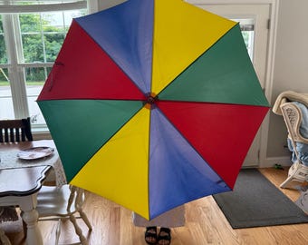 Sombrilla de playa vintage con mango de madera y rayas arcoíris de los años 80, con colores primarios LGBTQ (rojo, amarillo, azul y verde)