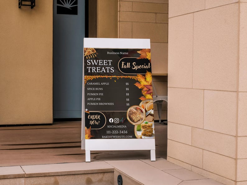 May include: A-frame sign advertising "Sweet Treats" and "Fall Special." The sign features a dark background with autumn leaves and images of baked goods. Menu items include caramel apple, spice buns, pumpkin pie, apple pie, and pumpkin brownies.