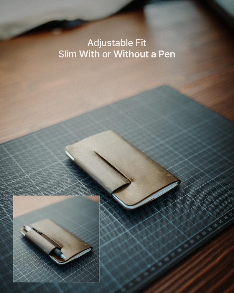 May include: A brown leather notebook cover with a wrap-around closure flap. The text "Adjustable Fit Slim With or Without a Pen" is visible. An inset shows the cover holding a pen, demonstrating its function as a slim, adjustable notebook holder.