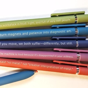 May include: A set of six retractable ballpoint pens in various matte colors including lime green, blue, purple, pink, and orange. Each pen features white printed text with unique phrases related to medical imaging and diagnostic work environments.