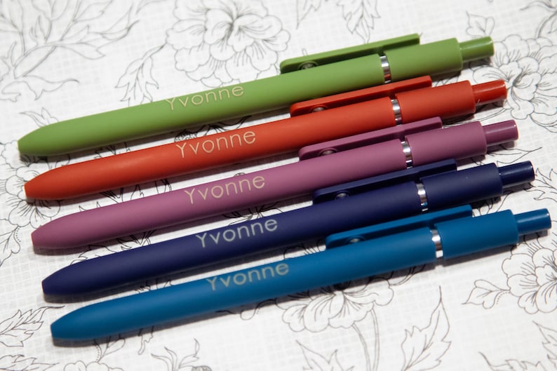 May include: Five pens in different colors: green, orange, purple, dark blue, and light blue. Each pen has the name "Yvonne" engraved on it.