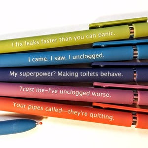May include: A set of six retractable ballpoint pens in lime green, blue, dark blue, purple, and orange. Each pen features white text: I fix leaks faster than you can panic, I came. I saw. I unclogged, My superpower? Making toilets behave, Trust me-I've unclogged worse, and Your pipes called-they're quitting.