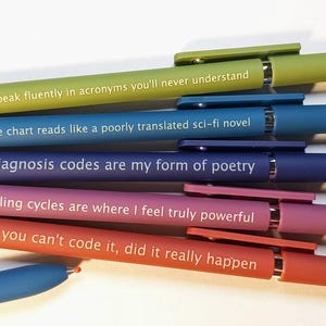 May include: A set of six retractable ballpoint pens in lime green, blue, dark blue, purple, orange, and light blue. Each pen features white text: I speak fluently in acronyms you'll never understand, The chart reads like a poorly translated sci-fi novel, Diagnosis codes are my form of poetry, Billing cycles are where I feel truly powerful, and If you can't code it, did it really happen.