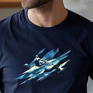 May include: Navy blue crew neck t-shirt with a geometric design of a rower in a boat. The graphic uses shades of blue and white, creating a dynamic and modern look. The shirt is made of a soft material.