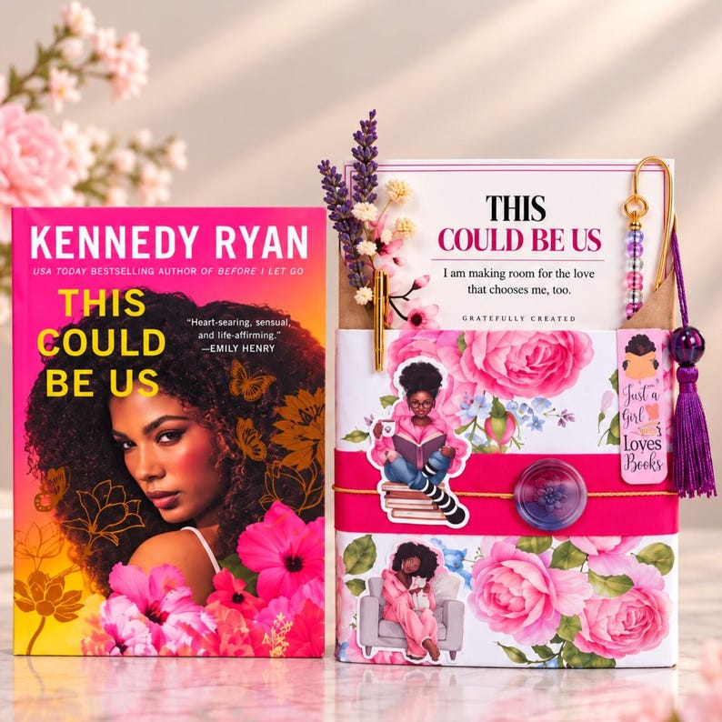 May include: A book titled This Could Be Us by Kennedy Ryan next to a gift set featuring a card with the same title, a gold pen, dried lavender, a beaded bookmark with a purple tassel, and a floral-patterned box with stickers.