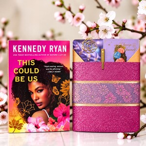 May include: A book titled This Could Be Us by Kennedy Ryan featuring a portrait of a person with dark curly hair surrounded by butterflies and hibiscus flowers, next to a glittery pink book sleeve with a metal rose bookmark and a gold pen.